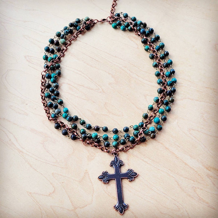 Necklace with cross pendant and turquoise beads.