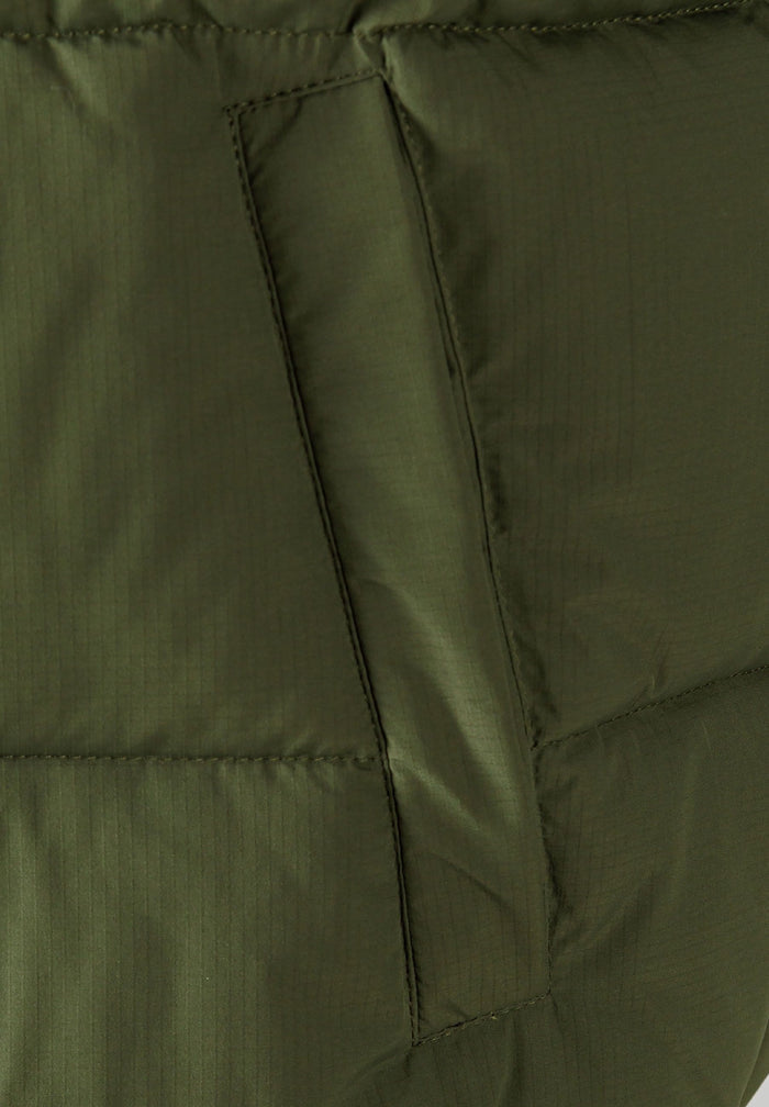 Detail of khaki padded gilet showing horizontal quilting and side pocket.