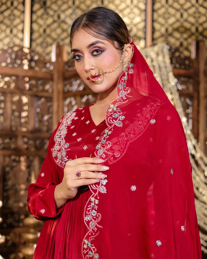 Woman wearing a red embroidered traditional outfit with a gold background