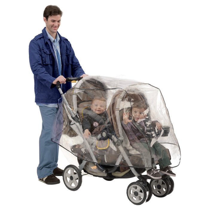 A man pushes a tandem stroller with two children inside, both smiling as the Tandem Stroller Weather Shield keeps them dry and protected under its transparent cover.