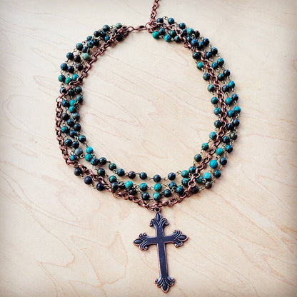 Necklace with cross pendant and turquoise beads.