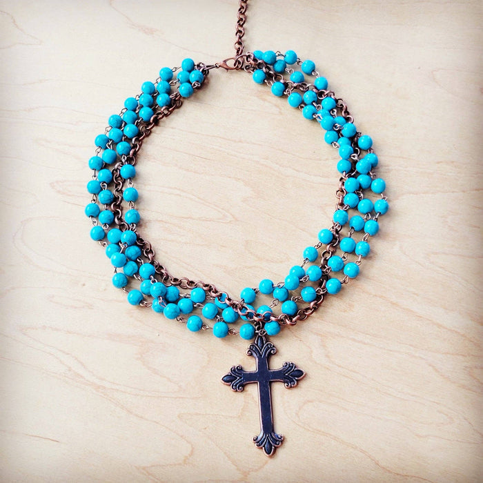Turquoise beaded necklace with a cross pendant.