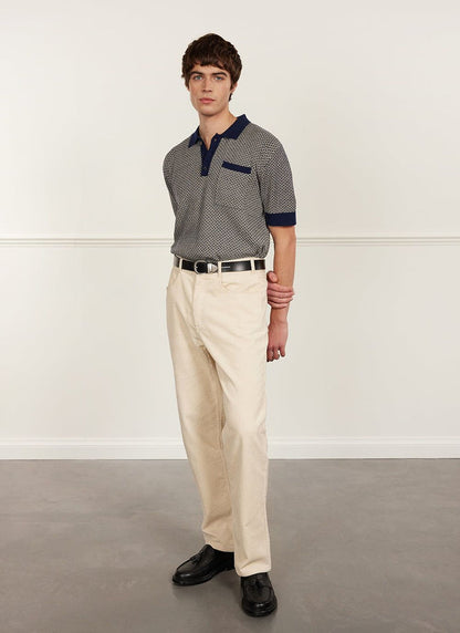 A model wears the Percival Casa Martini Knitted Polo in Navy with cream corduroy trousers and black loafers.