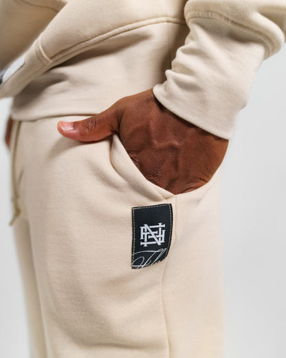 Close up of man wearing cream fleece set with hands in pockets