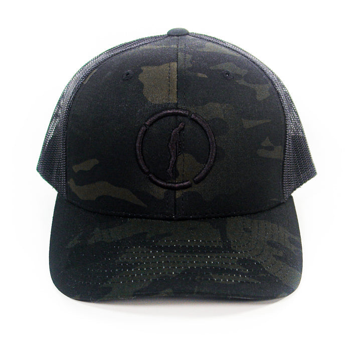 A black camouflage Hopesfall trucker hat with a mesh back and a subtle embroidered circle and figure logo on the front, displayed against a white background.
