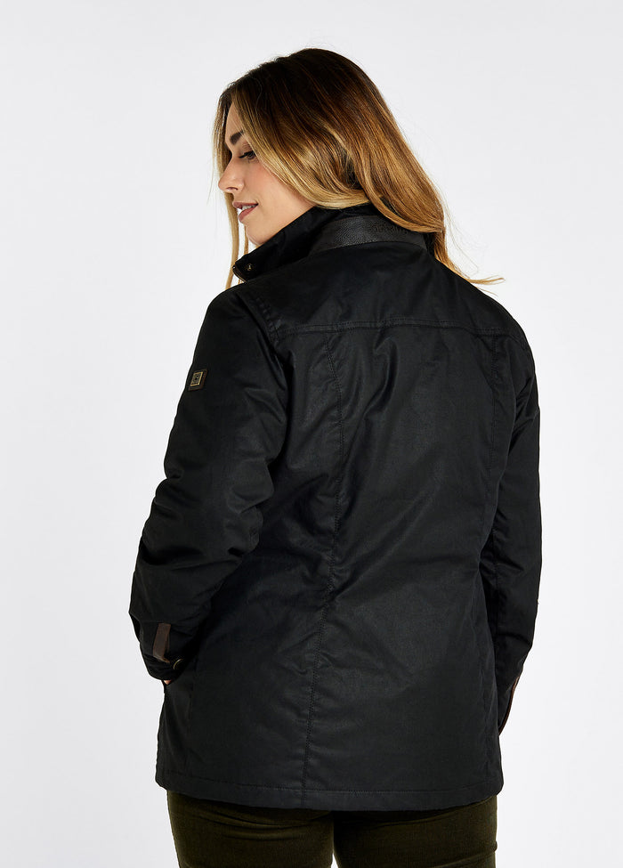 A female model showing the back of a Dubarry Mountrath Waxed jacket, black jacket, leather panel detail on the back of collar with Dubarry logo printed on to it