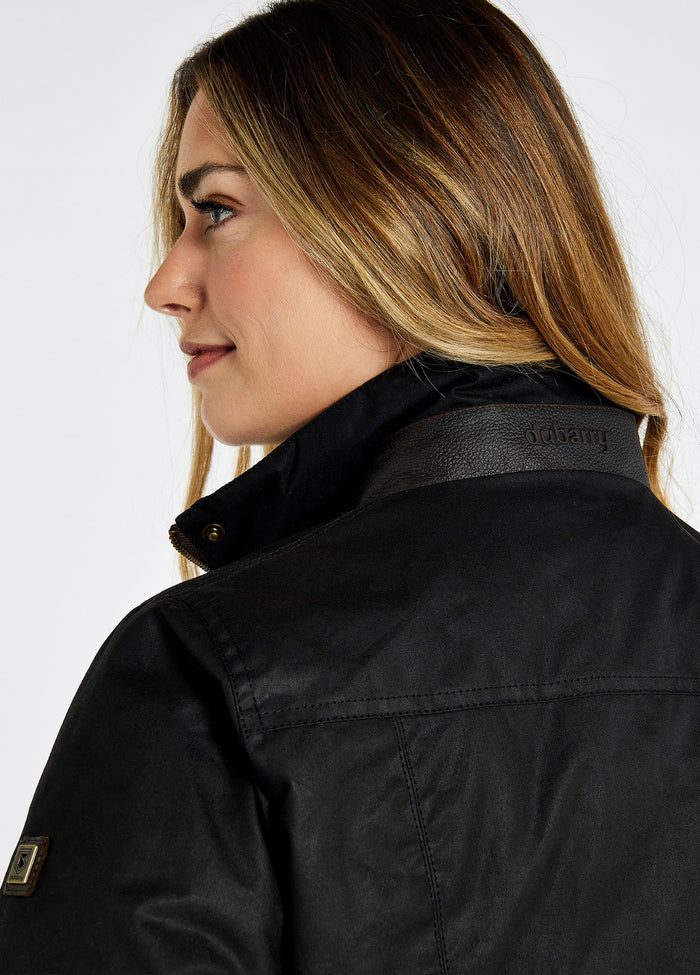 A female model showing the back of a Dubarry Mountrath Waxed jacket, black jacket