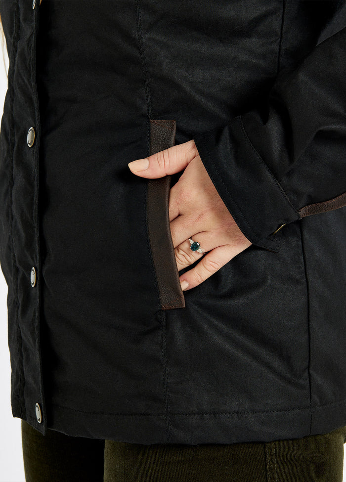 A female model showing the pocket of a Dubarry Mountrath Waxed jacket, black jacket