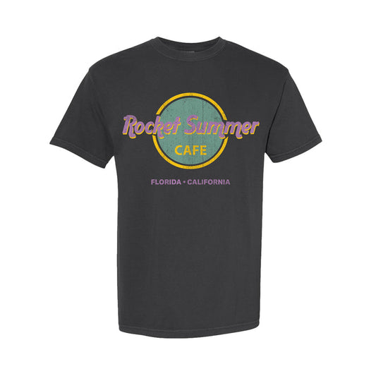 A black Comfort Colors T-shirt by The Rocket Summer, garment-dyed with a retro circular café logo in purple and yellow, featuring “Florida • California” beneath.