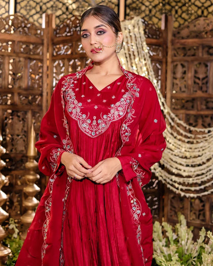 Woman wearing a red embroidered traditional outfit with a decorative background