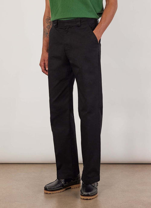 A model wears the Percival Stay Press Trousers in black. They are a straight leg fit made from a cotton twill canvas.