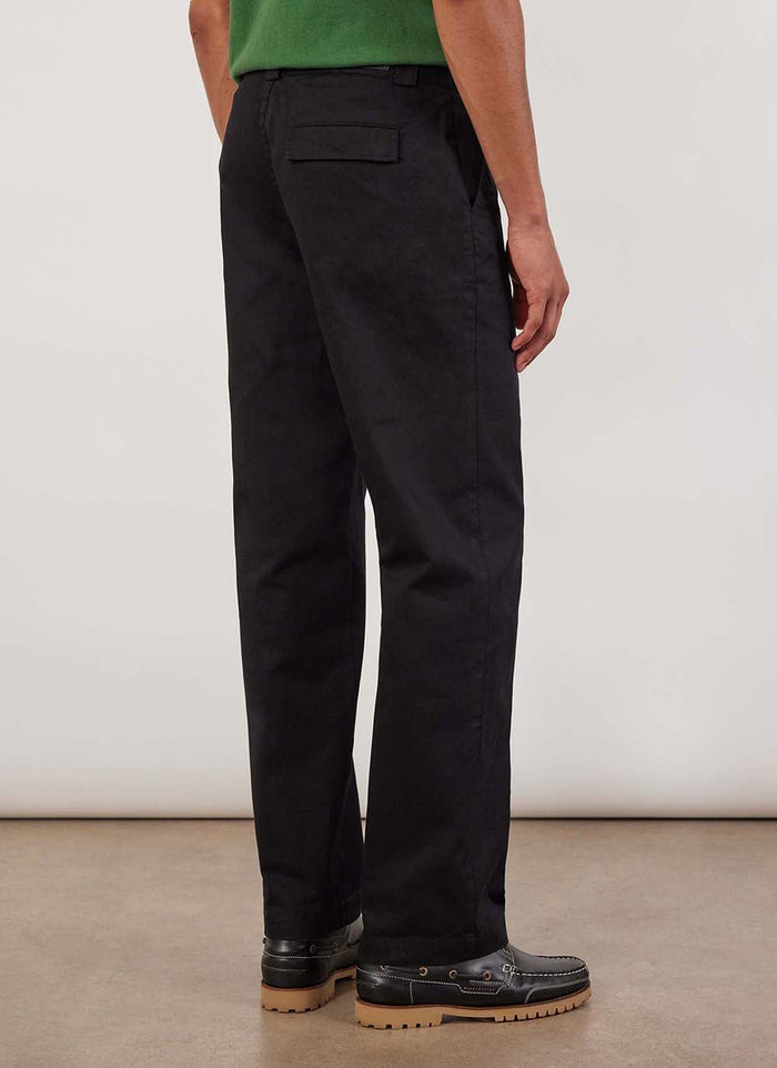 A model wears the black cotton twill Stay Press Trousers by Percival, showing the straight leg fit from the back.