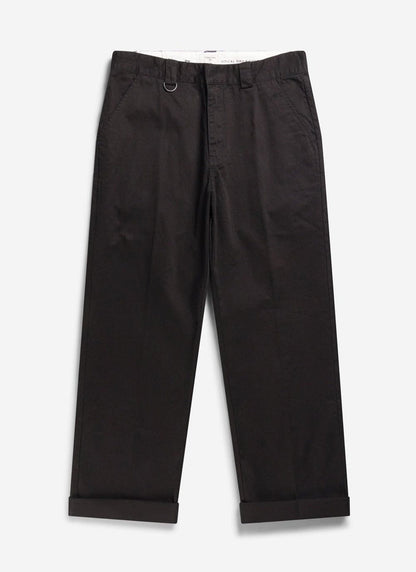 A flat lay image of the Percival Stay Press Trousers in black cotton twill with rolled up cuffs.