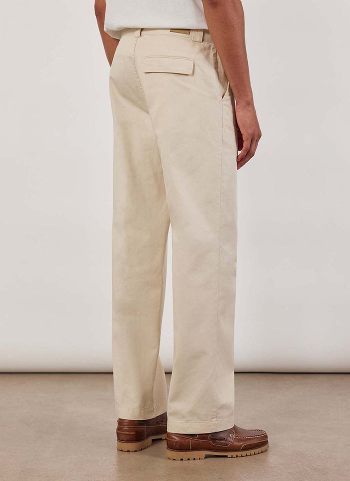 A model wears the Percival Stay Press Trousers in ecru, shot from the back to show the straight leg fit and back pocket.