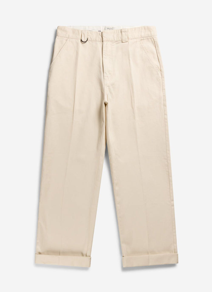A pair of Percival Stay Press Trousers in ecru cotton twill, laid flat with rolled up cuffs.