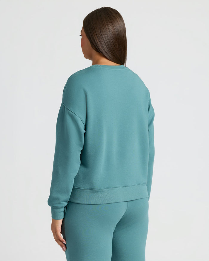 Back view of woman in Womens Stormcloud Slouch Pullover Crew & Relaxed Jogger set.